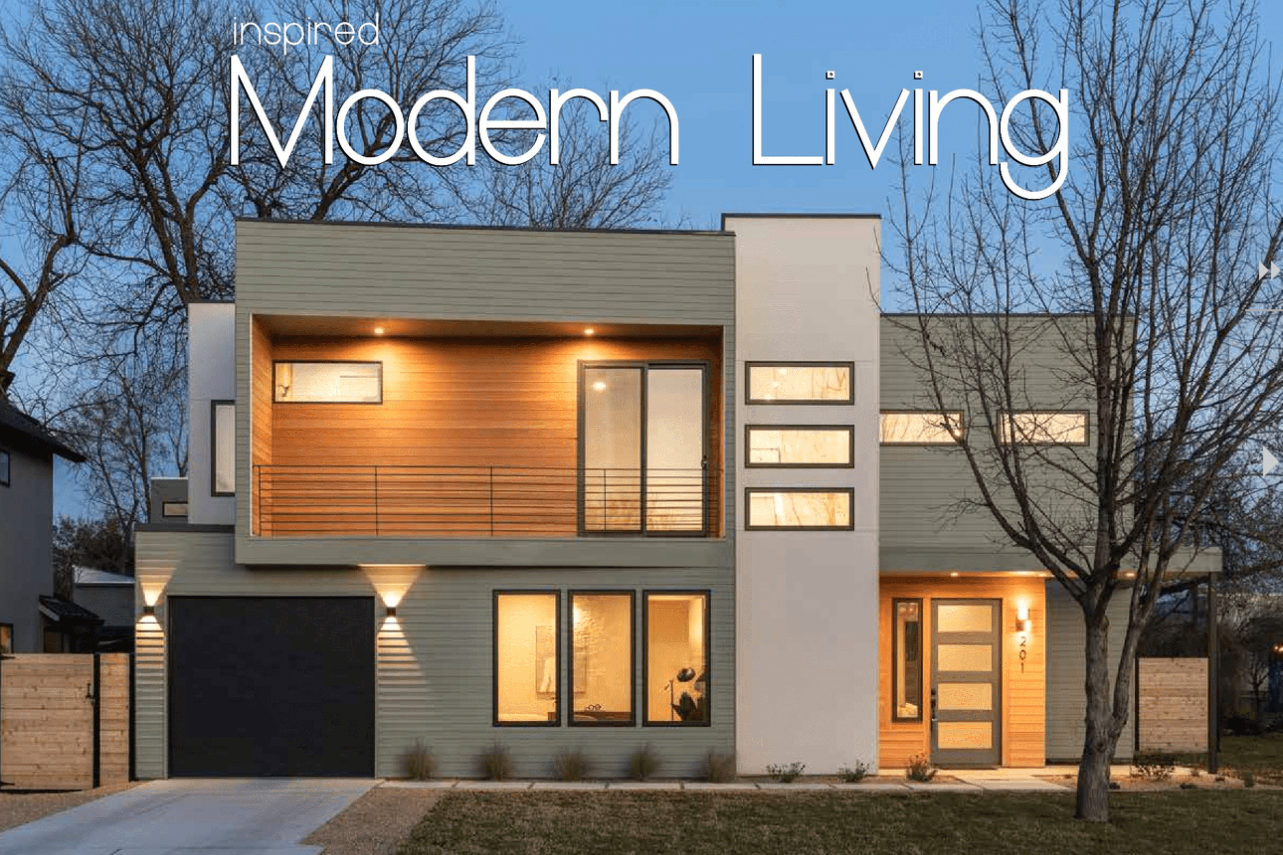 Two-story modern house with large windows, wood and white exterior, balcony, outdoor lights on, and bare trees in the yard; "Inspired Modern Living" text overlaid.